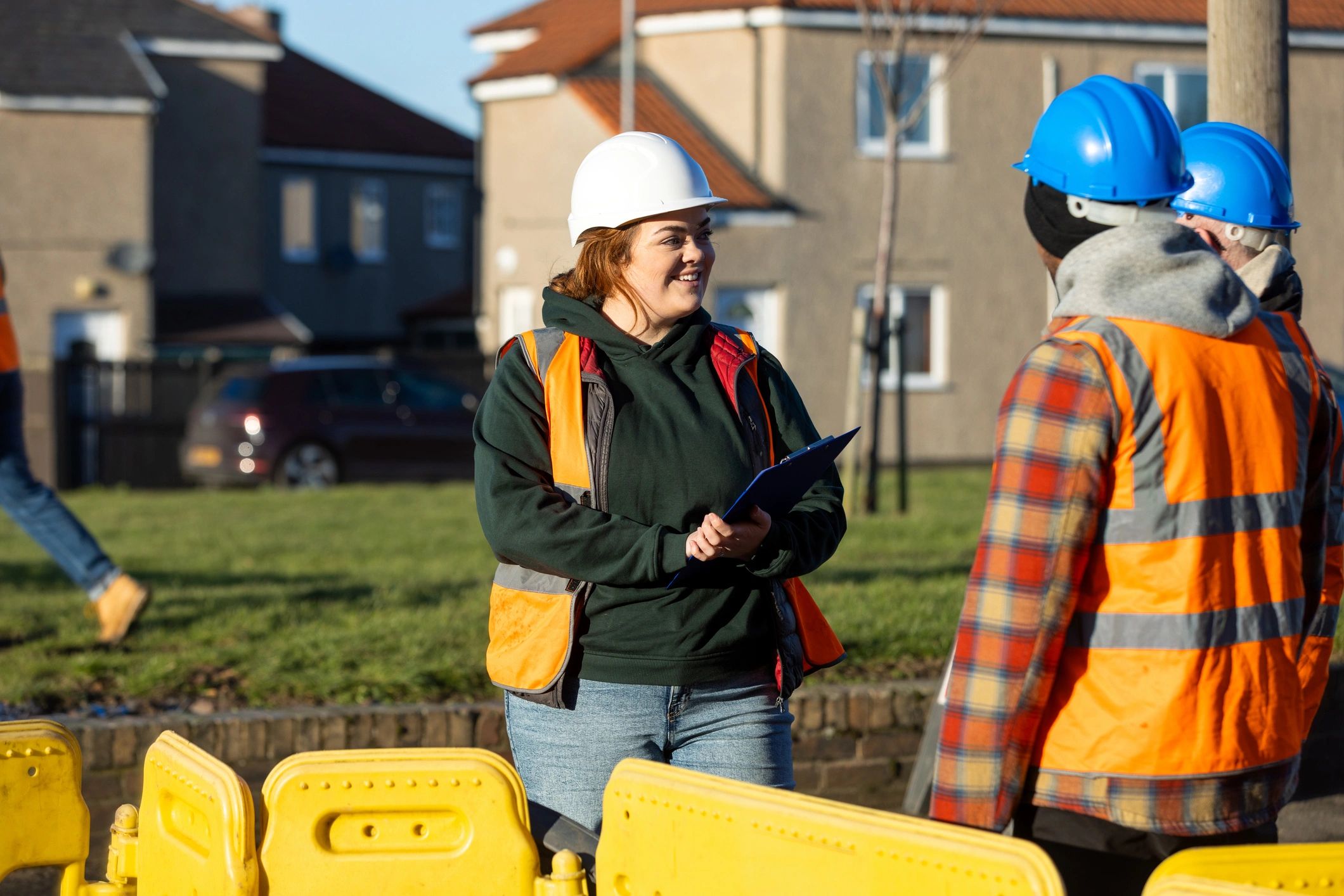 Construction team discussing plans at an active worksite